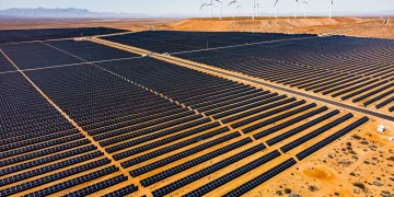 Expansive solar farm with wind turbines, symbolising US renewable energy commitment.